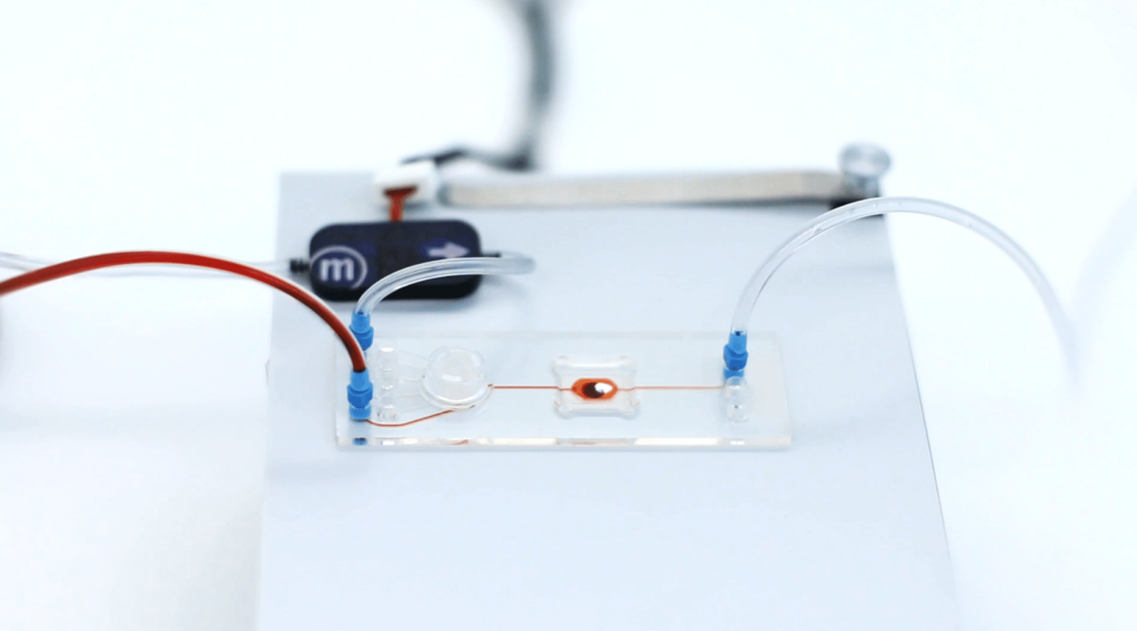 microfluidics banner showing a chip with microfluidic pathways and a micrpump in the background